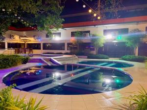 una piscina en el medio de un edificio por la noche en RedDoorz Covelandia Garden Resort Nueva Ecija, 