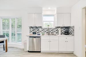 a white kitchen with white cabinets and a sink at Bellaire West Retreat in Houston
