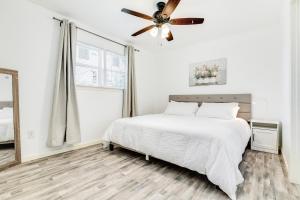a white bedroom with a bed and a ceiling fan at Bellaire West Retreat in Houston