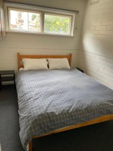 ein Schlafzimmer mit einem Bett in einem Zimmer mit zwei Fenstern in der Unterkunft Lyndoch Hotel in Lyndoch