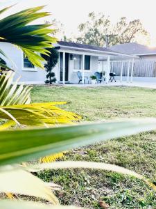 a white house with a yard with a house at 4 miles to Siesta Key Beach #1 in America in Sarasota