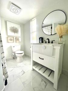 Baño blanco con lavabo y espejo en 4 miles to Siesta Key Beach #1 in America, en Sarasota
