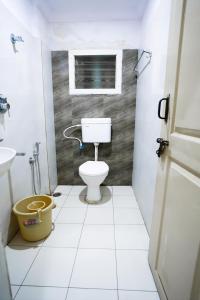 a small bathroom with a toilet and a window at HOTEL PRAKAASH RESIDENCY in Mysore