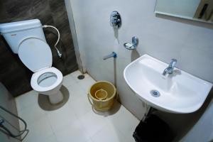 a bathroom with a white toilet and a sink at HOTEL PRAKAASH RESIDENCY in Mysore