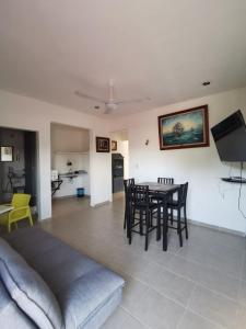 una sala de estar con una mesa y sillas en La casita del árbol, amplia y cómoda en barrio familiar, en Campeche