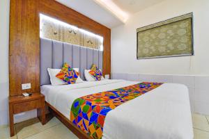 1 dormitorio con 1 cama grande y edredón colorido en FabHotel Royal King en Ahmedabad