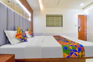 a bedroom with a bed with colorful pillows at FabHotel Royal King in Ahmedabad