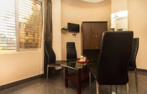 a living room with a glass table and chairs at Skyline Lodge in Siliguri