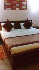 Bett mit Kissen darauf in einem Zimmer in der Unterkunft AKR Hotel Kilinochchi in Kilinochchi