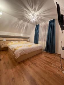 1 dormitorio con 1 cama con cortinas azules en Vila Roxy en Breaza