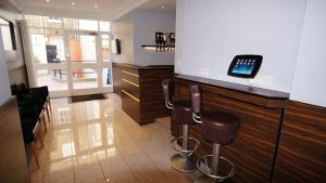 a bar with stools and a cell phone on a counter at Crestfield Hotel in London