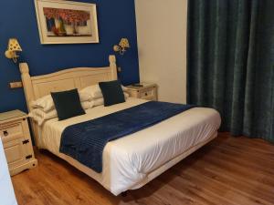 a bedroom with a large bed with blue walls at Puerta al Duraton in Sebúlcor