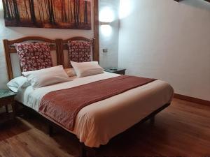 a bedroom with a large bed with two pillows at Puerta al Duraton in Sebúlcor