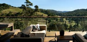 a couch on a deck with a view of a mountain at Fletchers Ridge - Main House in Montville
