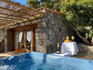 a blue hot tub in front of a stone building at Finca Aquilino y Carmen in Mogán