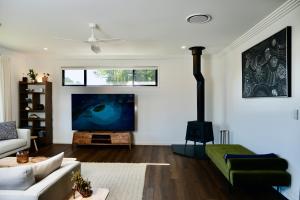 a living room with a flat screen tv and a fireplace at Fletchers Ridge - Main House in Montville