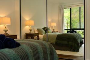 sypialnia z 2 łóżkami i dużym lustrem w obiekcie Fletchers Ridge - Main House w mieście Montville