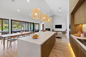 a kitchen and living room with a table and chairs at Moggs Creek Luxury Escape in Aireys Inlet