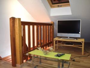 a living room with a television and a table with a table at Chalet Font-Romeu-Odeillo-Via, 5 pièces, 6 personnes - FR-1-580-39 in Font-Romeu-Odeillo-Via