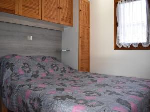 a bedroom with a bed with a flowered blanket at Chalet Font-Romeu-Odeillo-Via, 5 pièces, 6 personnes - FR-1-580-39 in Font-Romeu-Odeillo-Via