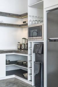 La cuisine est équipée d'un réfrigérateur et d'un four micro-ondes. dans l'établissement Loft Berawa 3 - Stunning 1-bdr luxury loft in Great Location !, à Canggu