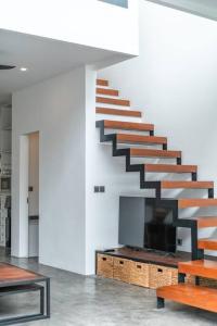 - un escalier dans un salon avec des escaliers en bois dans l'établissement Loft Berawa 3 - Stunning 1-bdr luxury loft in Great Location !, à Canggu