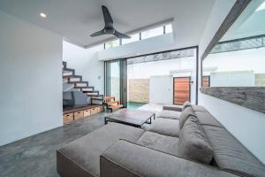 - un salon avec un canapé et un ventilateur de plafond dans l'établissement Loft Berawa 3 - Stunning 1-bdr luxury loft in Great Location !, à Canggu