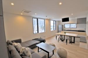 Myoko Apartments في Akakura: غرفة معيشة مع أريكة وطاولة