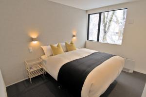 a bedroom with a large bed with a window at Myoko Apartments in Akakura