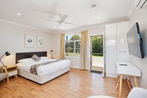 a bedroom with a bed and a desk and a tv at Wingham Motel in Wingham