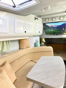 un camper con divano, tavolo e TV di Luxury Boat KARAMBA I a San Miguel de Abona