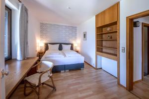 a bedroom with a bed and a desk and a chair at Chalet Carpe Diem in Kaprun