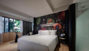 a bedroom with a white bed and a painting on the wall at PARKROYAL COLLECTION Kuala Lumpur in Kuala Lumpur +79 photos