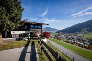 a house on a hill with a fence at Chalet Carpe Diem in Kaprun