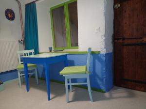 ディーにあるChambres d'hôtes Laurent Bessetの青いテーブルと椅子2脚が備わる客室です。