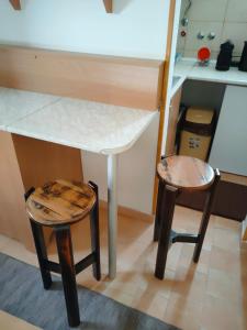 einen Tisch und zwei Hocker in einer Küche in der Unterkunft Sobica in Sremska Kamenica