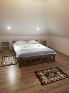 1 dormitorio con 1 cama y 2 alfombras en el suelo en Cabana Iriss, en Podu Coşnii