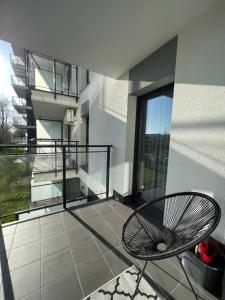 balkon z krzesłem i widokiem na budynek w obiekcie Apartament Rzeszów w mieście Rzeszów