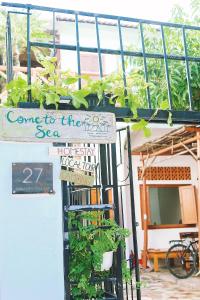 una señal en el lado de un edificio con plantas en Come to the Sea homestay Phú Yên, en Tuy Hoa