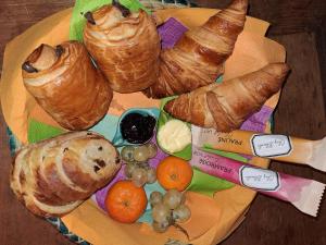 um prato de pastelaria e croissants numa mesa em La cave au chat'pitre / l'étable em Villers-le-Bouillet