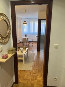 uma sala de estar com uma mesa e um espelho em Acogedor y soleado apartamento recién amueblado en Gijón em Gijón