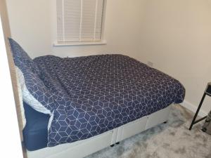 a bed with a blue comforter in a bedroom at 26 Lindhurst Way West in Mansfield