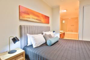 a bedroom with a bed and a bathroom at Indulge Apartments - Langtree in Mildura