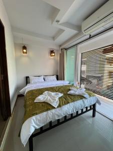 a bedroom with a large bed with towels on it at BB House Budget & Boutique in Chiang Mai