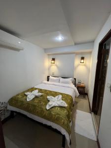 チェンマイにあるBB ハウス バジェット＆ブティックのベッドルーム1室(白い靴2本付きのベッド1台付)