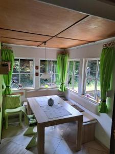 comedor con cortinas verdes y mesa de madera en Waldhaus St. Egidien, en Kurort Altenberg