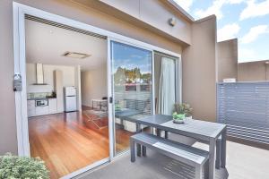 a living room with a table and a kitchen at Indulge Apartments - Langtree in Mildura