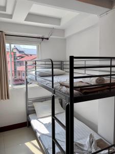 two bunk beds in a room with a window at BB House Budget & Boutique in Chiang Mai
