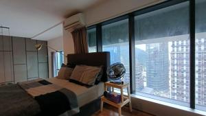 ein Schlafzimmer mit einem Bett und einem großen Fenster in der Unterkunft Signature LOFT EMPIRE CITY WIFI NETFLIX in Petaling Jaya