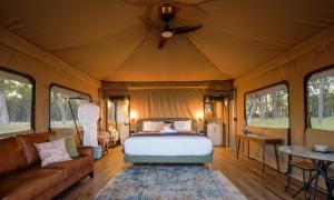 a bedroom with a bed and a couch and windows at Serenity Gully 